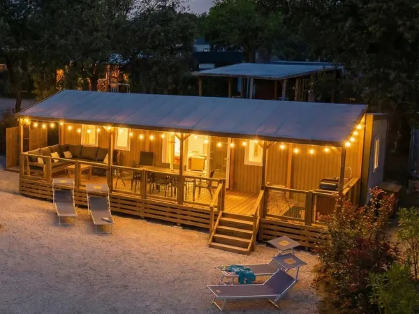 Strefa Premium Supreme Deluxe Lounge z nastrojowym oświetleniem na werandzie.