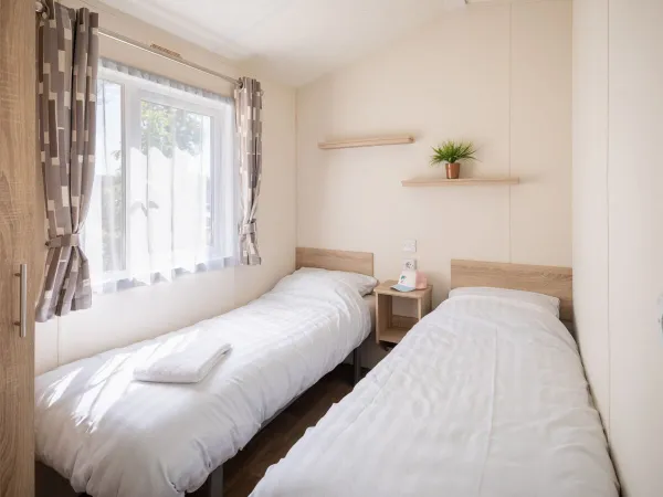 Druga sypialnia z dwoma pojedynczymi łóżkami w salonie Comfort Lounge.