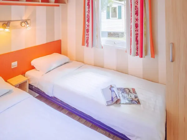 Sypialnia Roan Comfort Plus Lounge z dwoma pojedynczymi łóżkami.