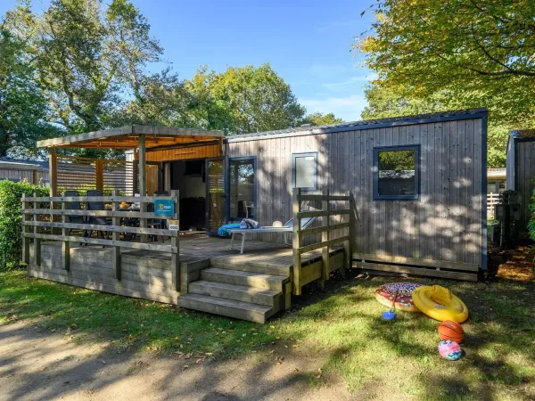 Na werandzie obiektu Roan Premium znajduje się stół z krzesłami ogrodowymi.