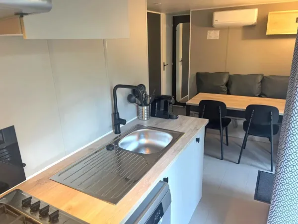W apartamencie Roan Premium Compact znajduje się przytulny salon ze stołem i kuchnią.