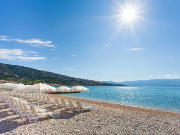 Kamienista plaża na kempingu Roan Baška Camping Resort.