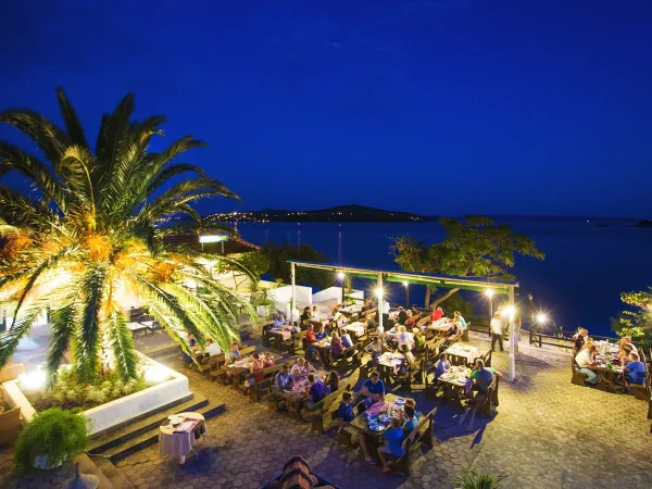 Przytulny wieczór na tarasie z widokiem na morze na kempingu Roan Amadria Park Trogir.