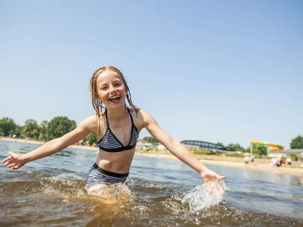 Dziewczyna pływa w naturalnym basenie w Roan Luxury Camping De Schatberg.