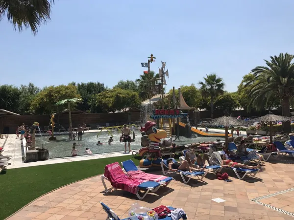 Leżaki przy basenie i wodny plac zabaw na kempingu Roan La Masia.
