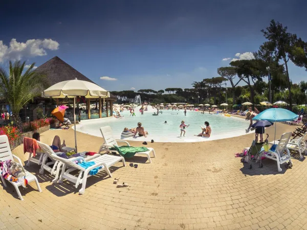 Leżaki przy basenie z laguną dla maluchów w wiosce Roan camping hu Park Albatros.