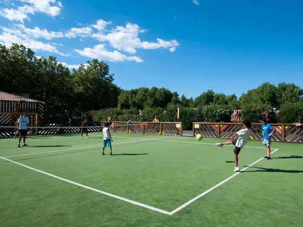 Gra w piłkę nożną na boisku wielofunkcyjnym na kempingu Roan Domaine de La Yole.