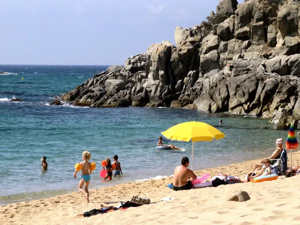 Piękna plaża przy skałach w pobliżu kempingu Roan Cala Gogo.