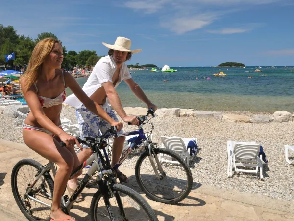 Jazda na rowerze wzdłuż kamienistej plaży na kempingu Roan w Valkanela.