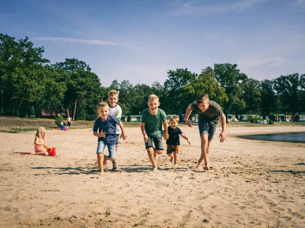 Piaszczysta plaża przy naturalnym basenie na kempingu Roan De Schatberg.