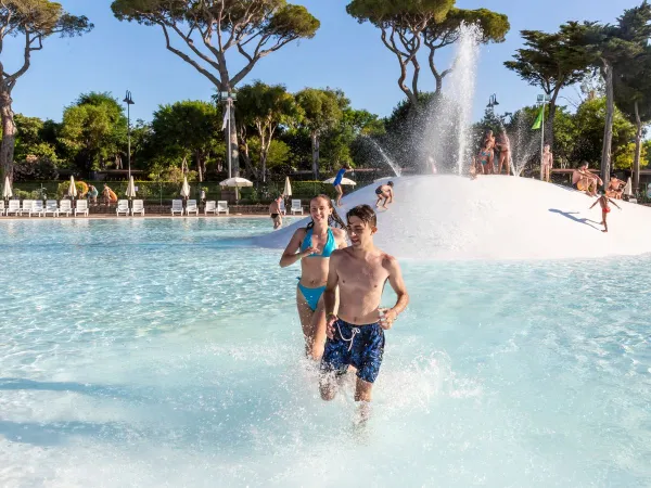 Dzieci biegają po basenie laguny w Roan camping hu Park Albatros village.