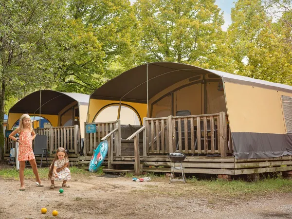 Dzieci bawią się przed Holiday Lodgetent na kempingu Roan La Rocca Manerba.