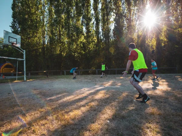 Gra w piłkę nożną na boisku wielofunkcyjnym na kempingu Roan w Château de Fonrives.