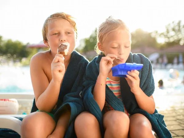 Dzieci jedzą lody na kempingu Roan des Ormes.