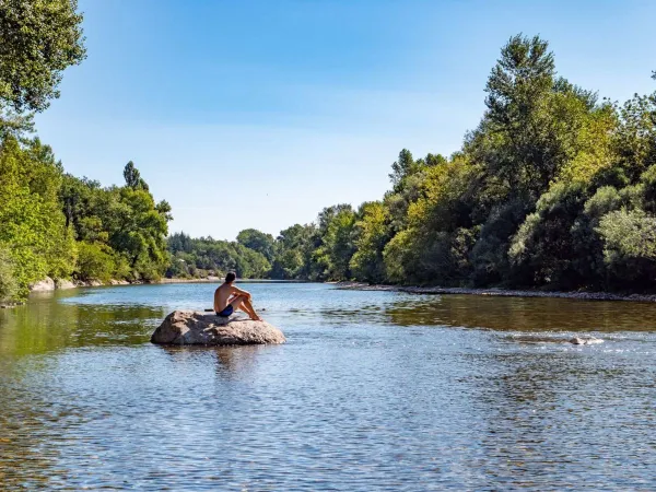 Zrelaksuj się na skale w rzece w pobliżu kempingu Roan Le Ranc Davaine.