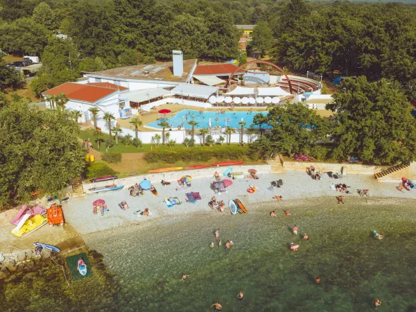 Przegląd żwirowej plaży i basenu na kempingu Roan Bijela Uvala.