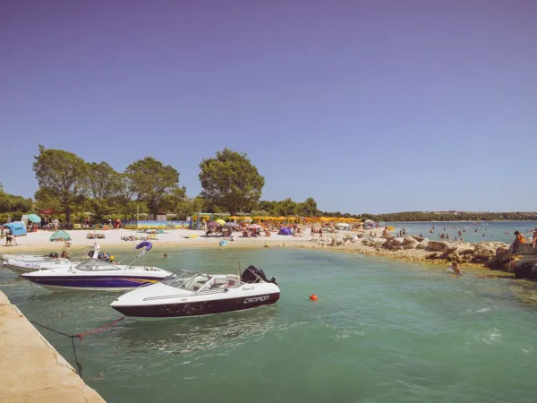 Plaża z pomostem i łodziami na kempingu Roan Bi Village.