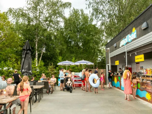 Ludzie wybierają coś smacznego z baru przy basenie na kempingu Roan Birkelt.
