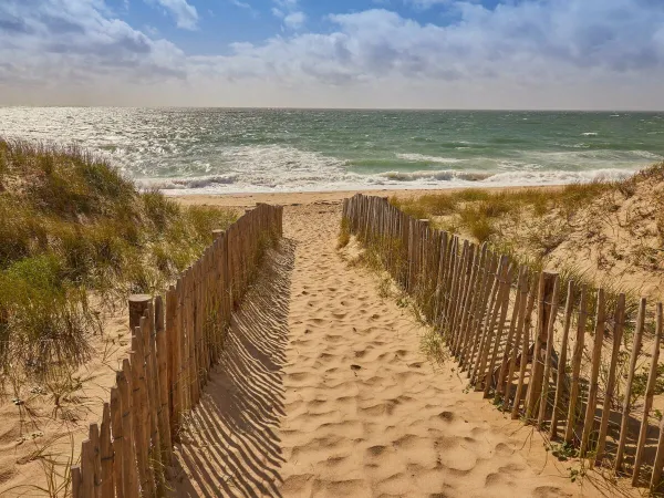 Ścieżka do piaszczystej plaży w pobliżu kempingu Roan Les Chardons Bleus de la Turballe.