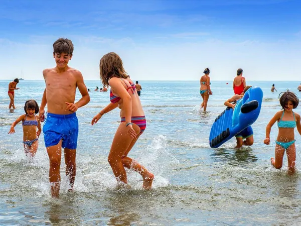 Dzieci bawią się w morzu na kempingu Roan w Sole Family Camping Village.