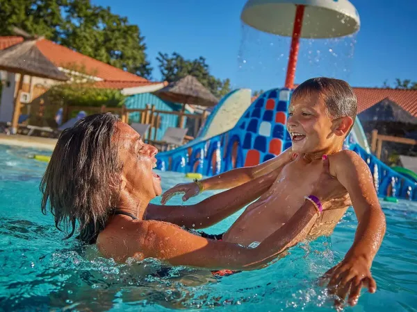 Matka i syn bawią się w basenie na kempingu Roan Mayotte Vacances.