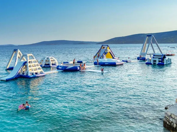 Wodny plac zabaw w morzu na kempingu Roan Amadria Park Camping Trogir.