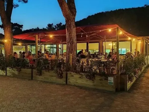 Pełna restauracja w nocy na kempingu Roan Del Forte.