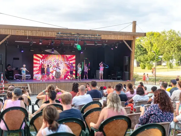 Wieczorna dyskoteka dla dzieci na scenie w Roan camping Château de Fonrives.