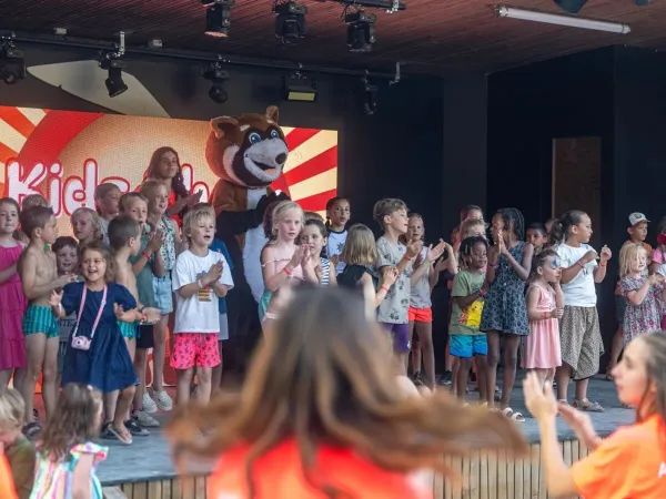 Radośnie śpiewające dzieci na scenie w Roan camping Château de Fonrives.