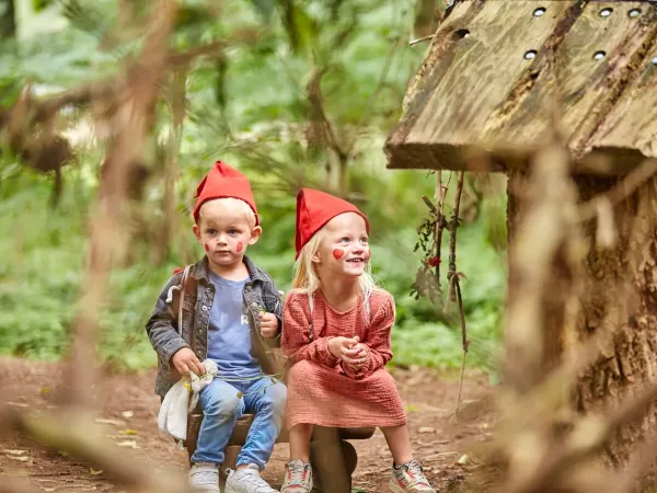 Dwoje małych dzieci w czapkach gnomów podczas wędrówki gnomów na kempingu Roan Terspegelt.