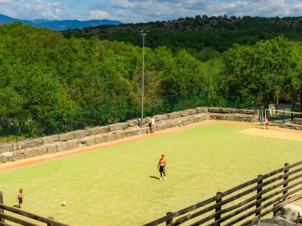 Gra w piłkę nożną na boisku sportowym na kempingu Roan Aluna Vacances.