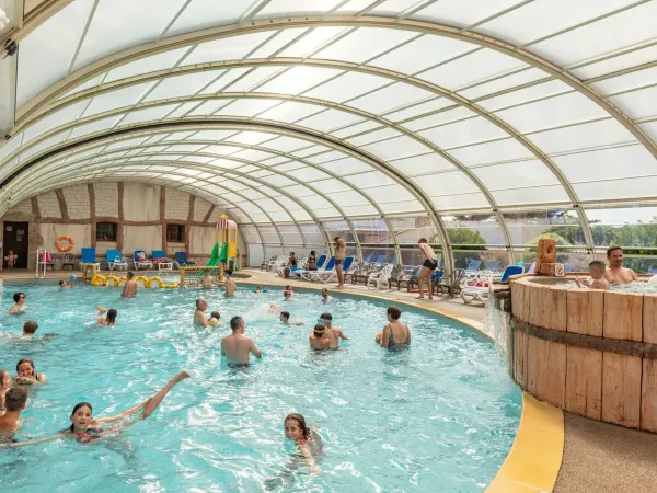 Kryty basen ze zjeżdżalnią wodną na kempingu Roan Le Domaine de Beaulieu.