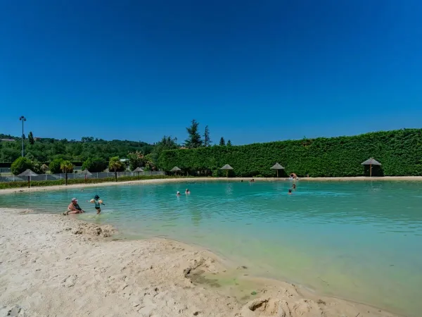 Rajski basen lagunowy z plażą na kempingu Roan Chateau de Galaure.