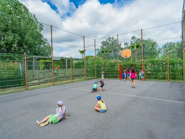 Dzieci bawią się na wielofunkcyjnym boisku sportowym na kempingu Roan Les Méditerranées Beach Garden.
