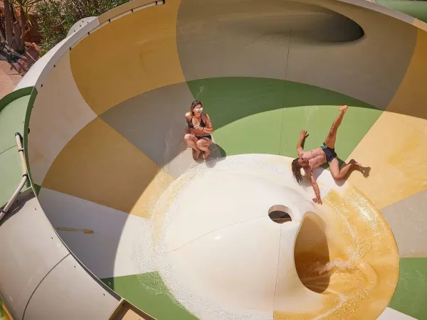 Dwie osoby bawią się na zjeżdżalni tornado na kempingu Roan Le Petit Mousse.