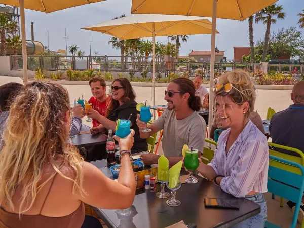 Wznoszenie toastów na tarasie kempingu Roan Le Petit Mousse.