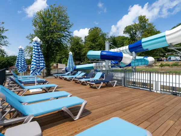 Taras słoneczny i zjeżdżalnia na kempingu Roan Le Lac des Vieilles Forges.