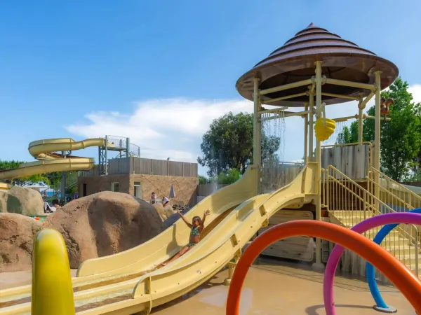 Dziewczynka zjeżdża ze zjeżdżalni dla dzieci na kempingu Roan Arinella Bianca.