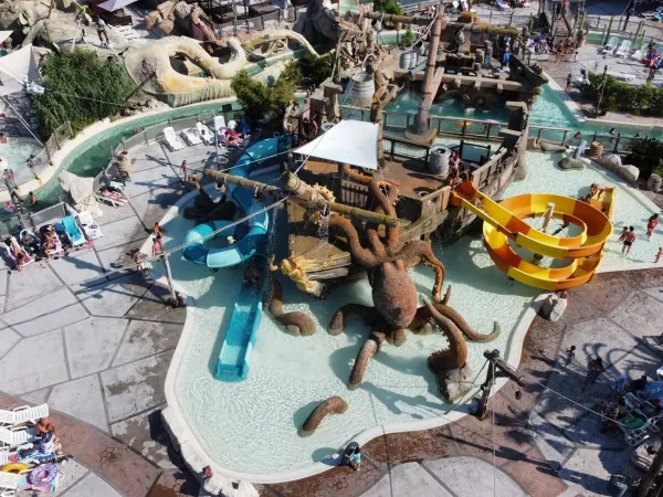 Wodny plac zabaw ze zjeżdżalniami w kształcie statku pirackiego na kempingu Roan Les Sables d'Or.