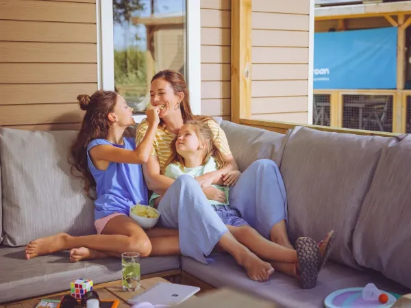 Matka i dzieci bawią się na sofie w salonie Roan.