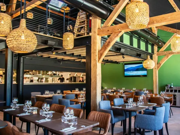 Klimatyczna restauracja z otwartą kuchnią na kempingu Roan Domaine des Ormes.