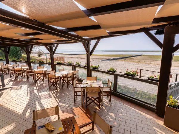 Restauracja z widokiem na plażę i morze na kempingu Roan Tenuta Primero.