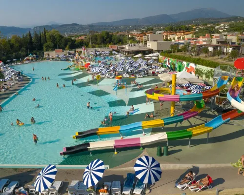 Kompleks basenów ze zjeżdżalniami i urządzeniami do zabawy w wodzie na kempingu Roan Cisano San Vito.