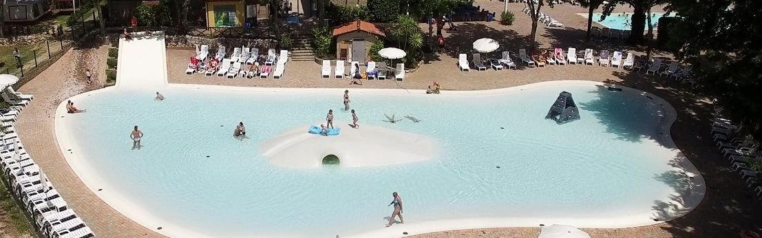 Lagunowy basen ze zjeżdżalnią na campingu I Pini blisko Rzymu we Włoszech