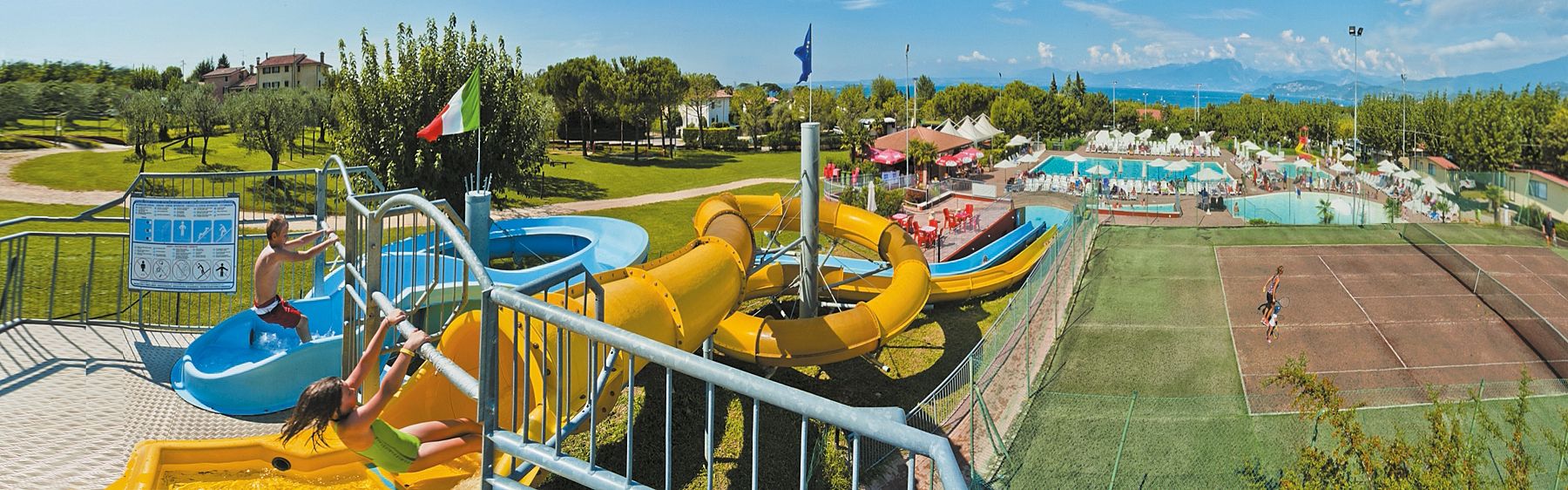 Basen ze zjeżdżalniami oraz korty tenisowe na campingu Park Delle Rose nad Jeziorem Garda we Włoszech